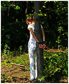 Bound to a tree Natalie wets her white jeans